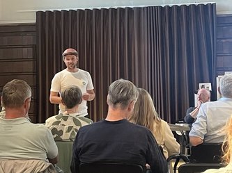 Jannes Brusermann hält sein Statement zum Lütti in Bramsche. Im Vordergrund sind Menschen im Publikum. 